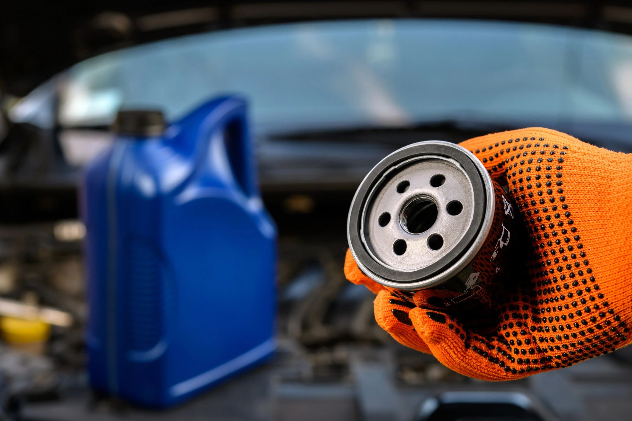 Mechanic holding a new oil filter in a repair shop